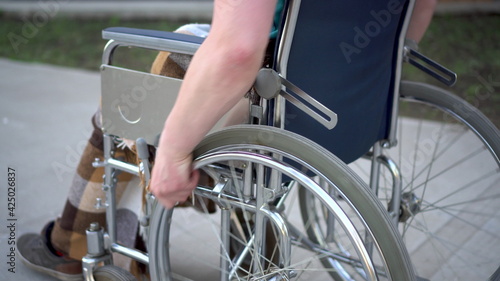 Young man in a wheelchair. A man rides in a wheelchair close-up hand. Special transport for the disabled.