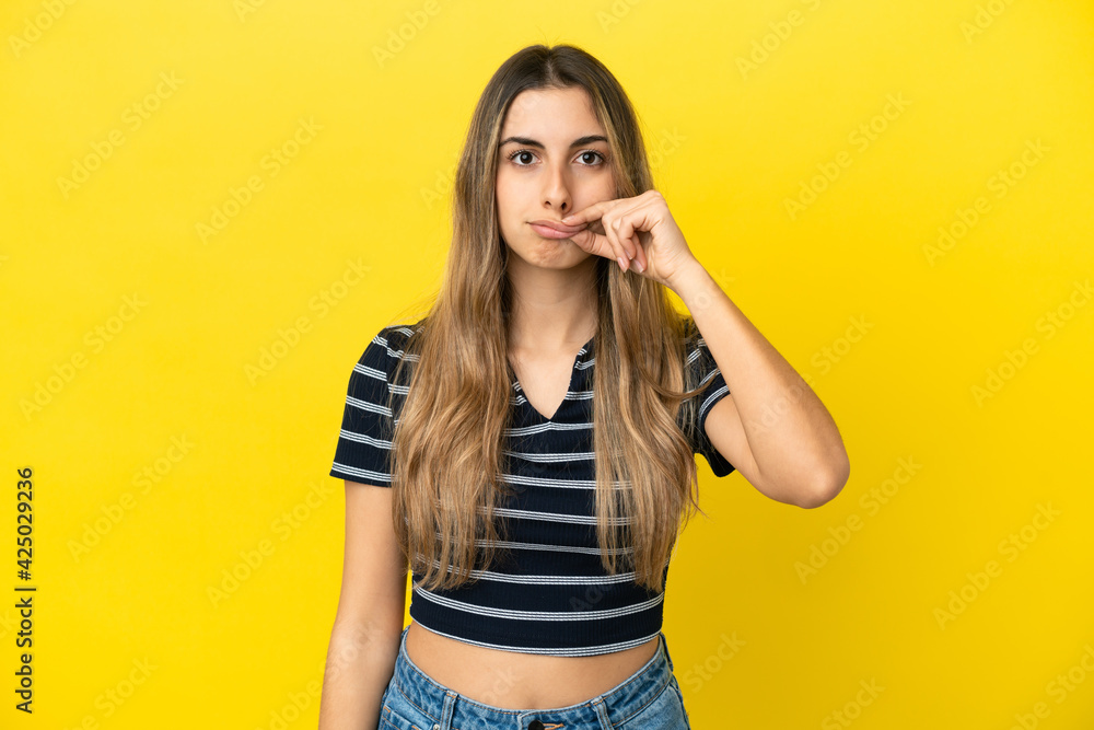 Young caucasian woman isolated on yellow background showing a sign of silence gesture Young caucasian woman isolated on yellow background showing a sign of silence gesture
