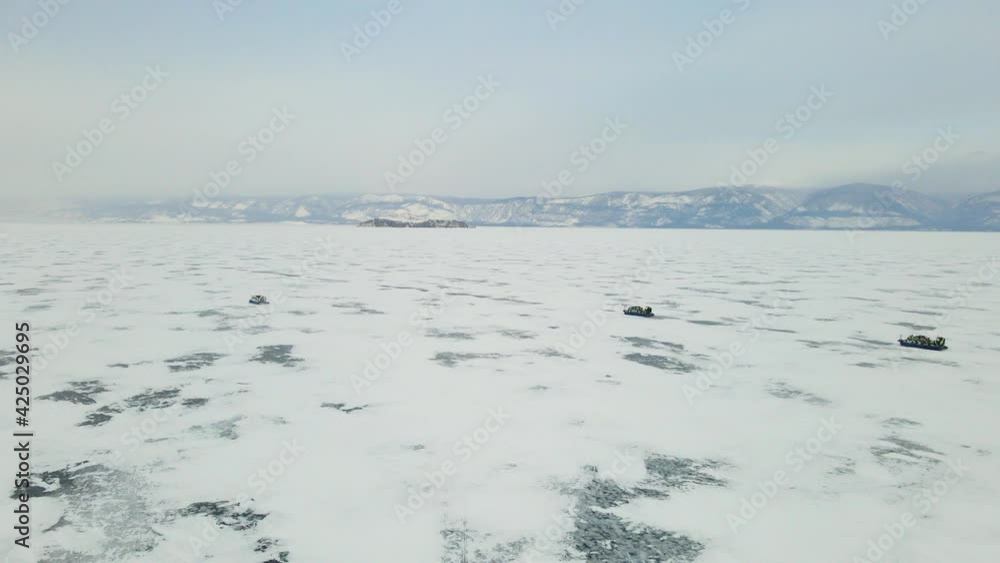 Hovercraft Gliding on Beautiful Frozen Ice Surface of Baikal Lake in Winter in Russia. Aerial View Hovercraft Gliding on Beautiful Frozen Ice Surface of Baikal Lake in Winter in Russia. Aerial View