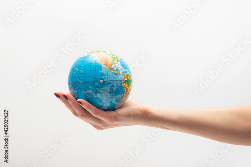 Small globe in a female hand. World in human hands