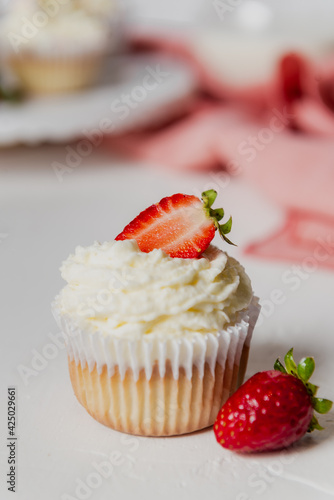 Muffins Cupcake cream decorated with colorful sprinkles on white background and strawberries 