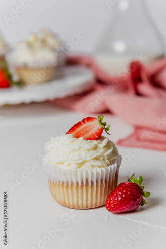 Muffins Cupcake cream decorated with colorful sprinkles on white background and strawberries 
