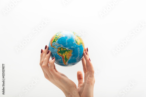 Beautyful female hand holds globe. World in human hands. White background