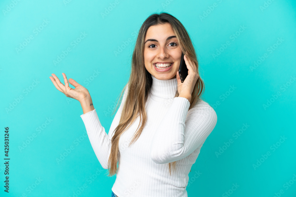 Young caucasian woman using mobile phone isolated on blue background extending hands to the side for inviting to come Young caucasian woman using mobile phone isolated on blue background extending hands to the side for inviting to come