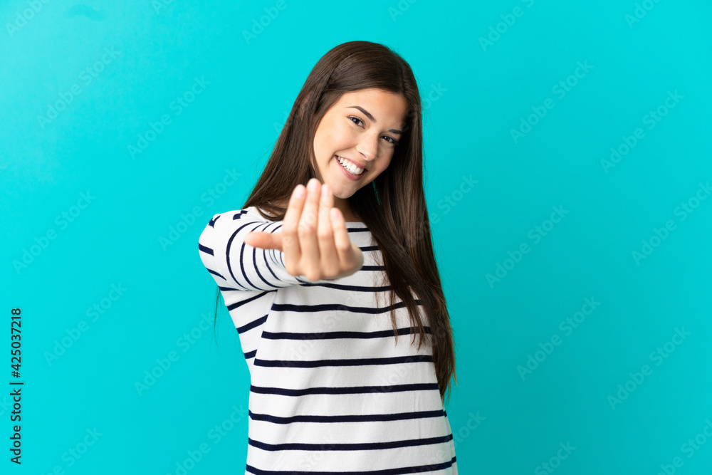 Teenager Brazilian girl over isolated blue background inviting to come with hand. Happy that you came Teenager Brazilian girl over isolated blue background inviting to come with hand. Happy that you came