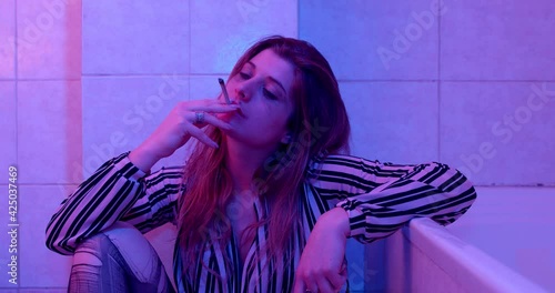 high on drugs -depressed girl in the bathroom smokes weed to escape from reality photo