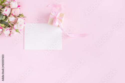 Gift box, flowers and greeting card on pink background. Flat lay. Birthday, wedding, anniversary or mother's day concept. © Kira