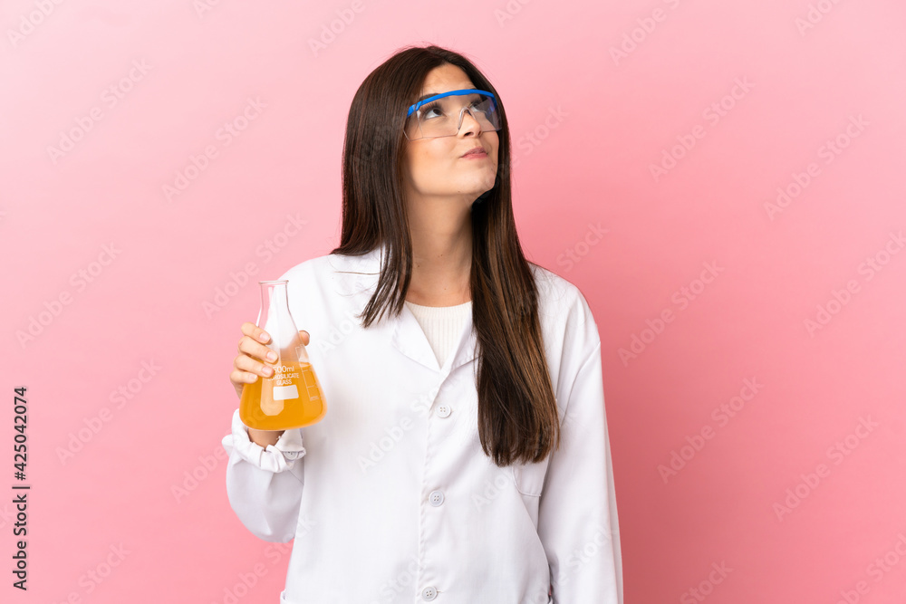 Young scientific girl over isolated pink background and looking up Young scientific girl over isolated pink background and looking up