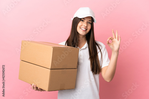 Delivery girl over isolated pink wall showing ok sign with fingers