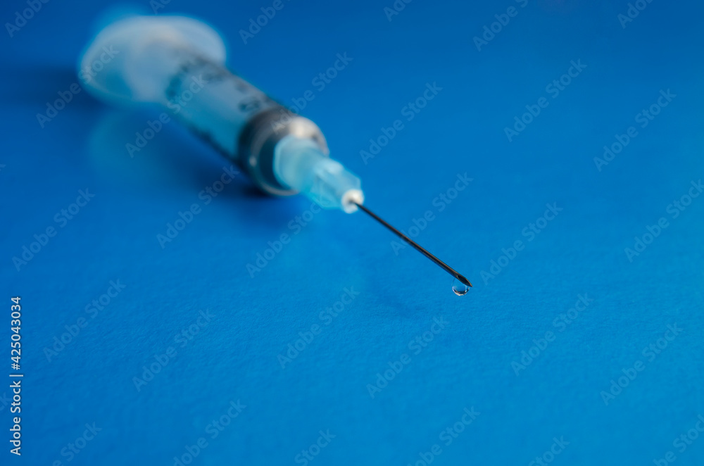 Medical syringe with a needle at the end of the drop Medical syringe with a needle at the end of the drop