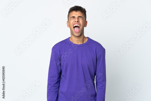 Young brazilian man isolated on white background shouting to the front with mouth wide open