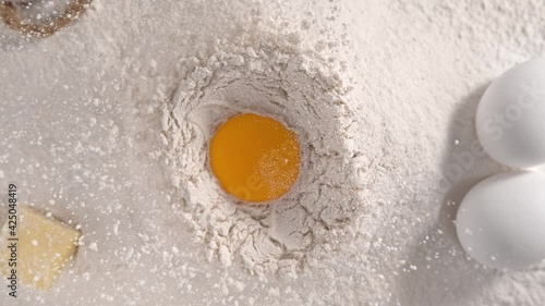 Raw Egg Yolk Falling into Pile of Flour Making Hole in Slow Motion 1000fps - Top View