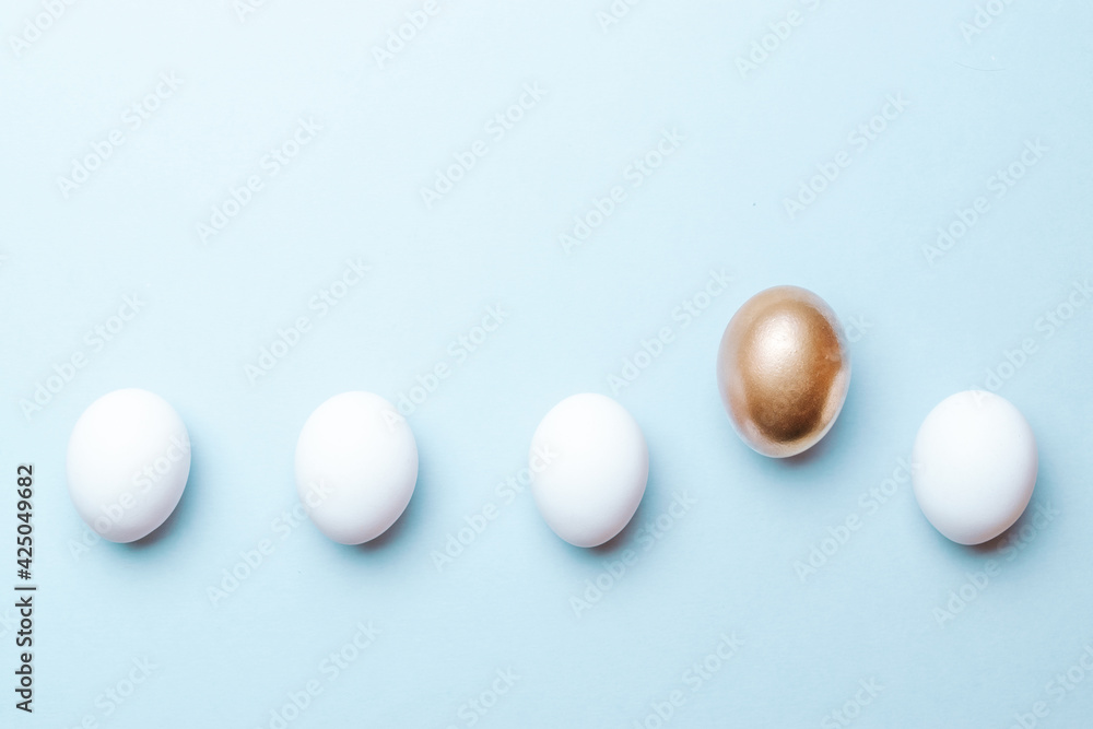 Easter background blue. Golden, white colour egg on pastel blue background in Happy Easter decoration. Flat lay, top view. Easter background blue. Golden, white colour egg on pastel blue background in Happy Easter decoration. Flat lay, top view.