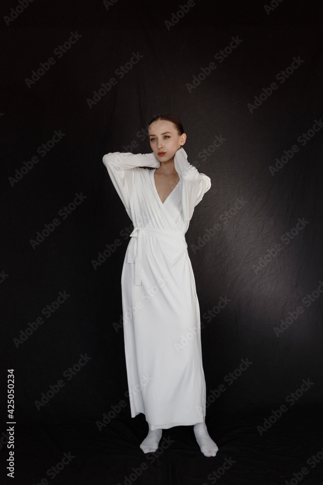 A pale girl in a white dress, the style of a modern geisha. Portrait of a beautiful girl isolated on a dark background. A pale girl in a white dress, the style of a modern geisha. Portrait of a beautiful girl isolated on a dark background.
