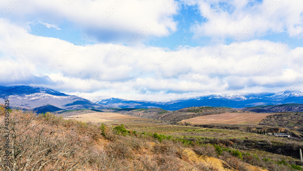 Spring landscape of foothills and snow-capped mountains Spring landscape of foothills and snow-capped mountains