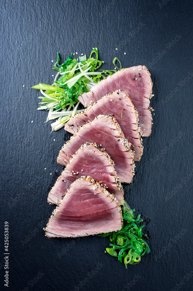 Traditional Japanese tuna tataki with leek and wakame served as top