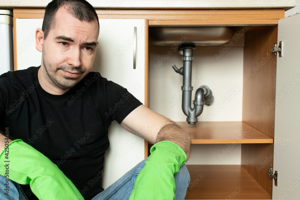 Drain Problems, blockage plumbing kitchen sink pipe unclog male man sit tired Drain Problems, blockage plumbing kitchen sink pipe unclog male man sit tired