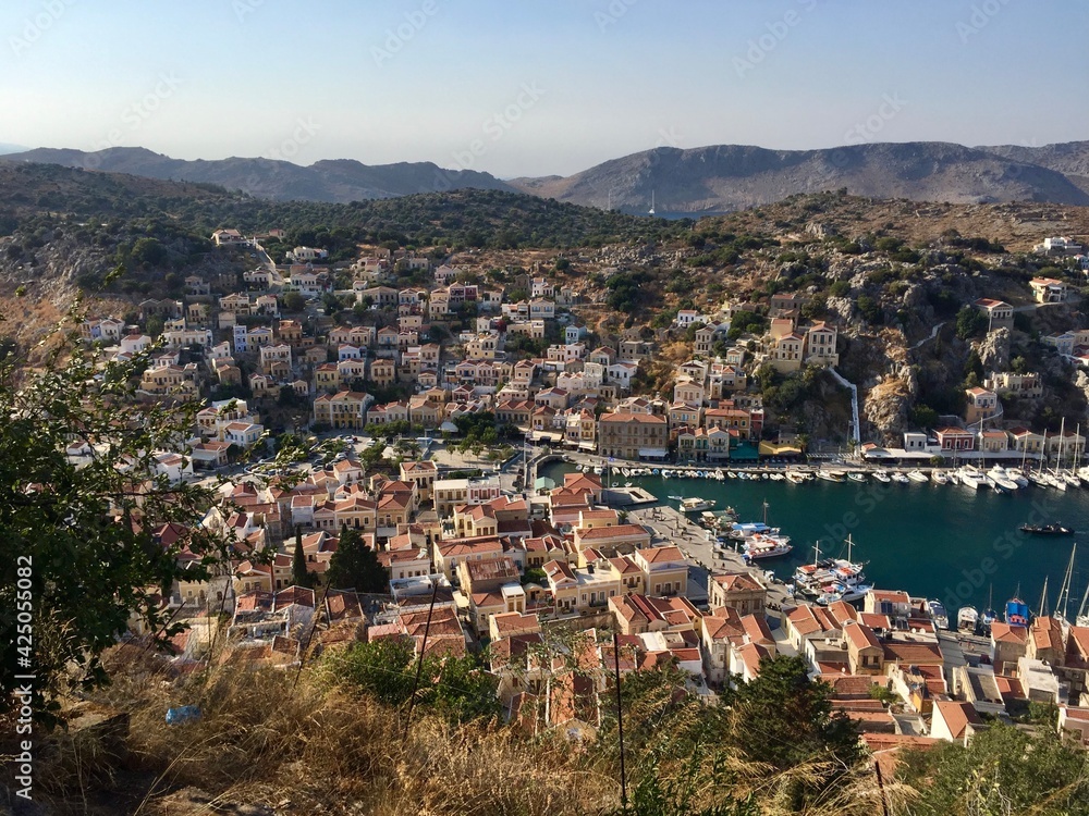 Symi island panoramic view from the top of hill. Greece. Marina, yachts, colourful houses, mountain. Date of photo is 18.08.2019.