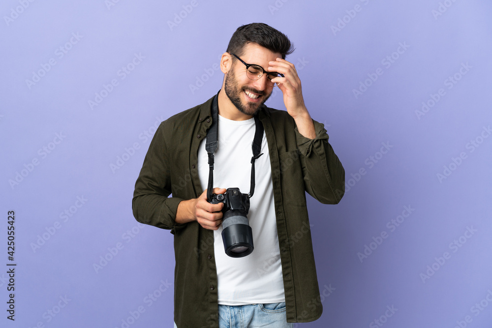 Photographer man over isolated purple background laughing Photographer man over isolated purple background laughing