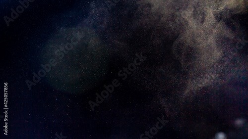 Background of fine dust on black, cloud of fine coffee particles