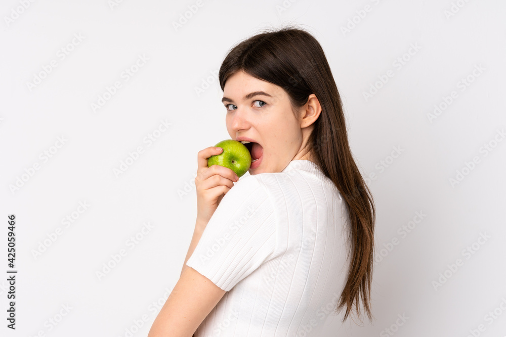 Young Ukrainian teenager girl over isolated white background eating an apple Young Ukrainian teenager girl over isolated white background eating an apple
