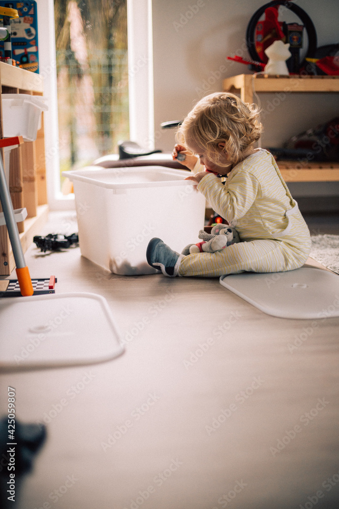 bébé joue comme un grand, seul dans sa chambre en pyjama bébé joue comme un grand, seul dans sa chambre en pyjama