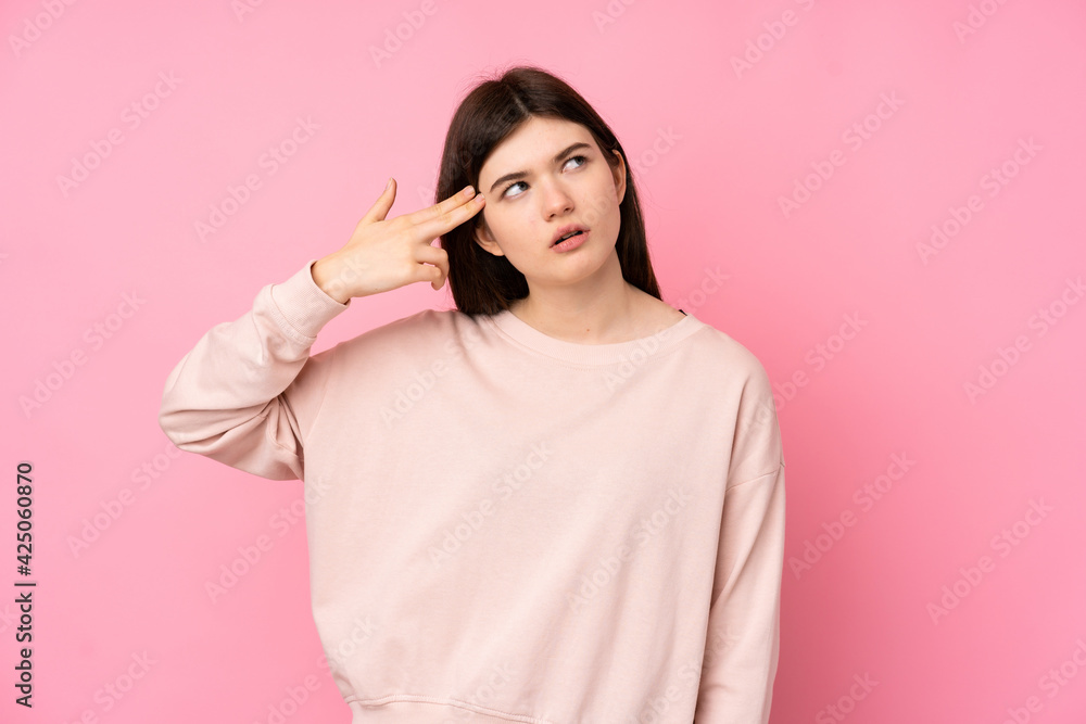 Young Ukrainian teenager girl over isolated pink background with problems making suicide gesture Young Ukrainian teenager girl over isolated pink background with problems making suicide gesture