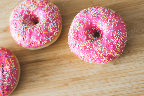 Sugar addiction: Close up of sugar sprinkled pink donut photo