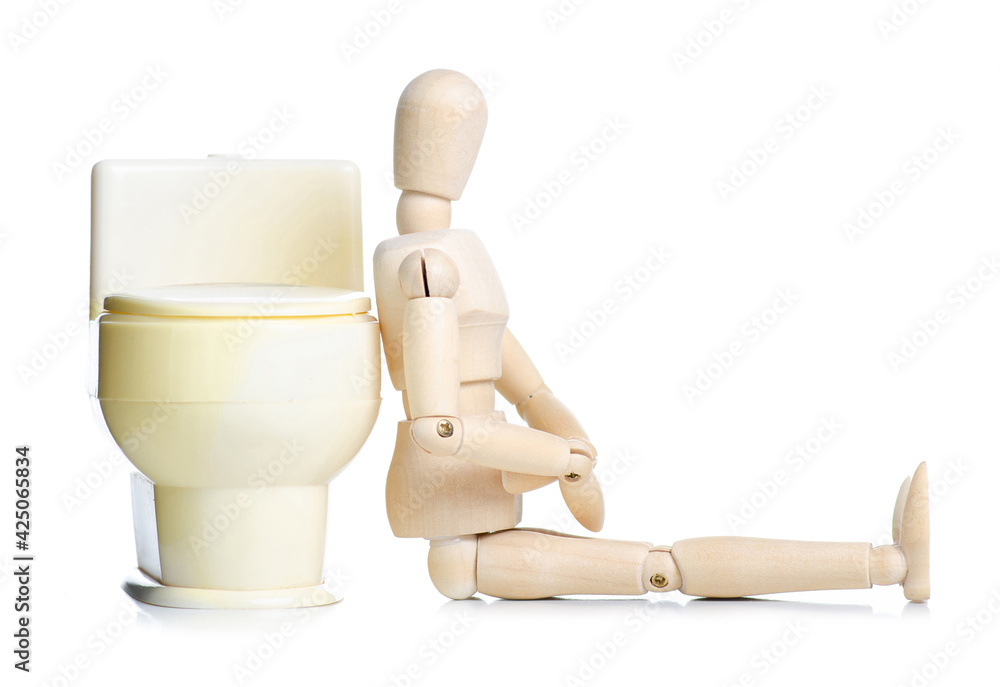 Wooden man with toilet on white background isolation. Concept of the problem with digestion. Wooden man with toilet on white background isolation. Concept of the problem with digestion.