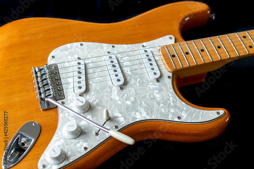 Fotografie Electric guitar stratocaster with pearl pickguard, on black background