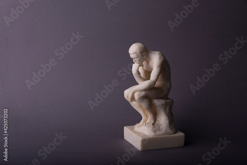 Carta da parati Rodin thinker statuette of the naked man on the grey background