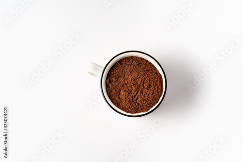 Black coffee powder in a white cup top view isolated on white background.