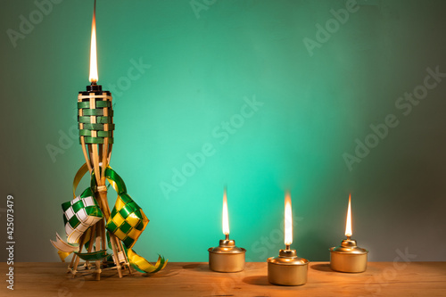 Conceptual traditional Malay torch and lamp and decorative ketupat during Hari Raya Aidilfitri celebration
