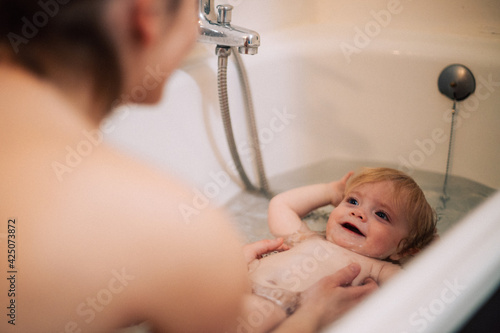 Schilderij op canvas Petite fille prend son bain avec maman, regarde maman, amour