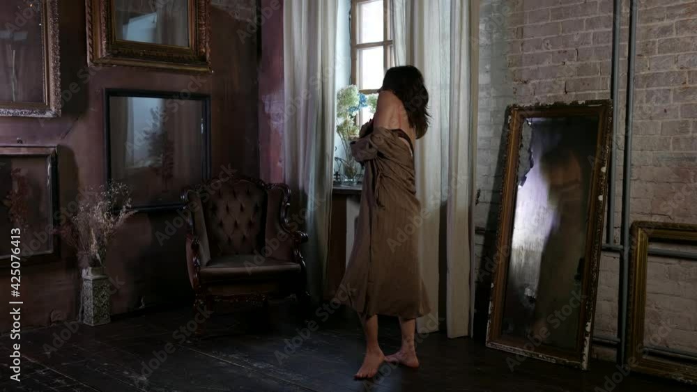 adult lady is dressed lingerie and silk gown is dancing alone in living room with romantic interior adult lady is dressed lingerie and silk gown is dancing alone in living room with romantic interior