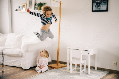 Foto Petit garçon saute du fauteuil au dessus de sa sœur