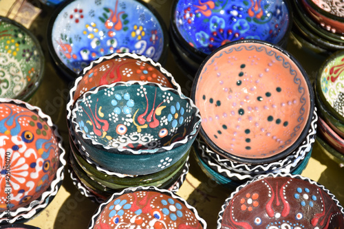 Colorful hand painted ceramics for sale in a flea market. Traditional oriental and ottoman culture patterned bowls