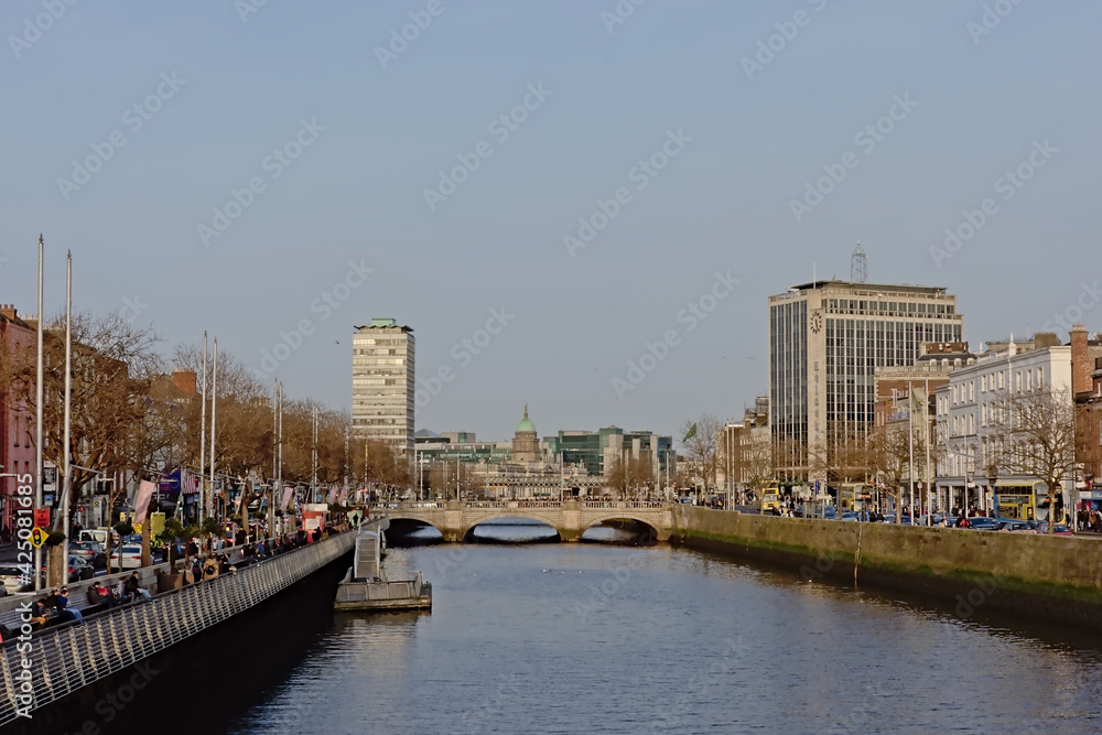 river Liffey through the city of Dublin, with historic buildings and bridges and modern office and apartment towers