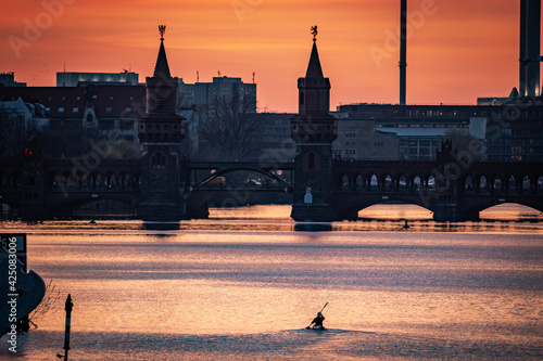 Photography person paddling with canoe in spree to oberbaum bridge in berlin