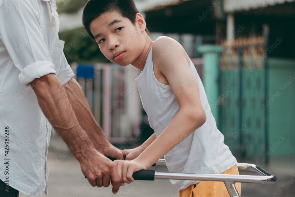 Disabled child is doing physical with father in the evening, He is ready to practice, Special children's lifestyle, Life in the education age of special need children, Happy disability kid concept. Disabled child is doing physical with father in the evening, He is ready to practice, Special children's lifestyle, Life in the education age of special need children, Happy disability kid concept.