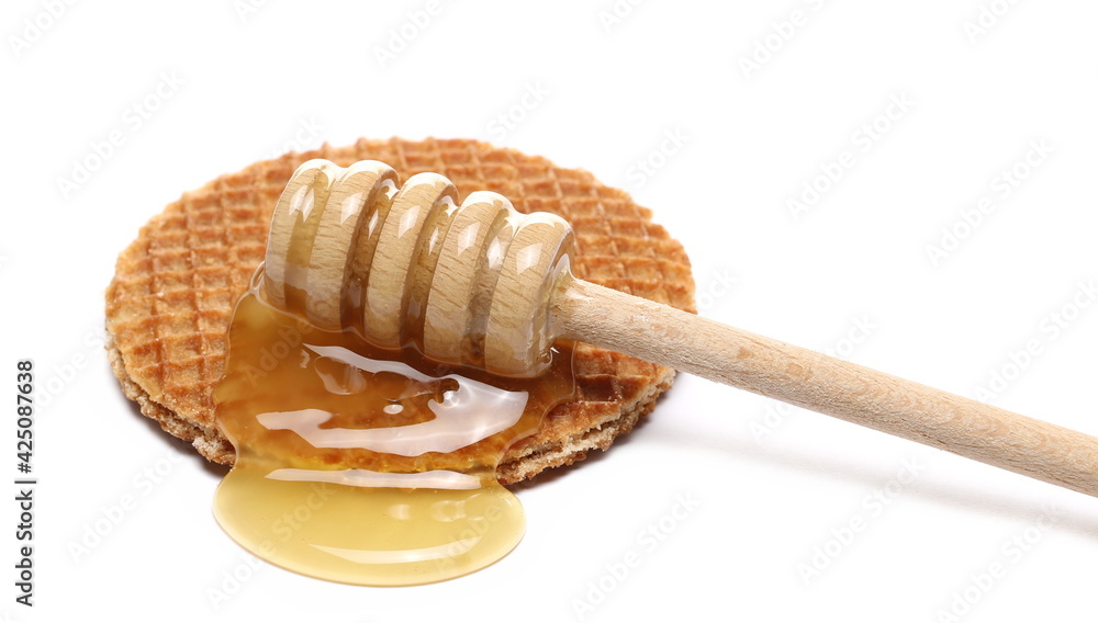 Dutch waffles with honey and wooden dipper isolated on white background Dutch waffles with honey and wooden dipper isolated on white background