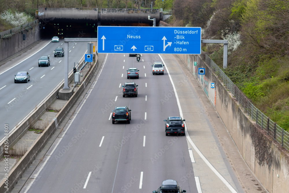 Empty German Autobahn in Dusseldorf with blue street signs and white arrows without traffic jam shows multiple lane highway ready for rush hour in corona times as free freeway in German cities Empty German Autobahn in Dusseldorf with blue street signs and white arrows without traffic jam shows multiple lane highway ready for rush hour in corona times as free freeway in German cities