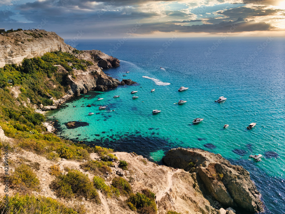 View of a beautiful bay with turquoise water and many boats at sunset