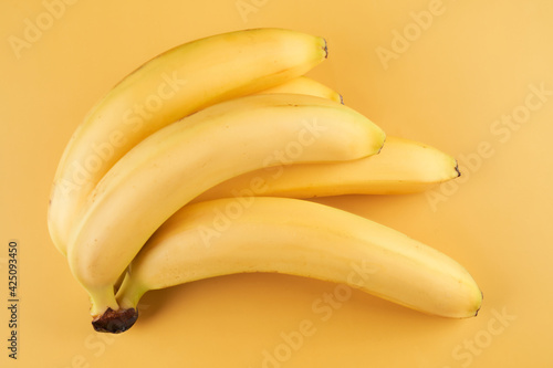 Bunch of whole bananas isolated on yellow background with copy space
