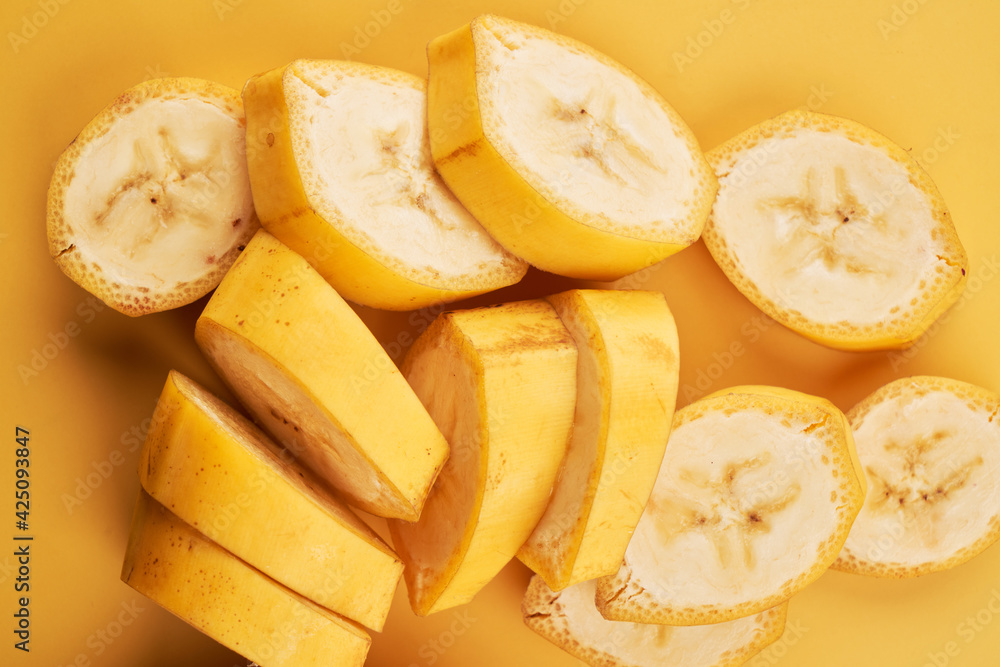 Sliced bananas on yellow background close up, healthy dessert ingredient Sliced bananas on yellow background close up, healthy dessert ingredient