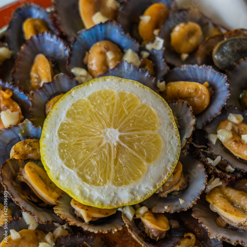 Seafood - grilled limpets served with lemon. Lapas grelhadas. photo