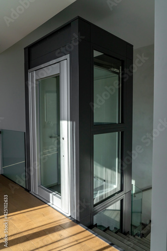 Apartment interior with modern glass elevator. Architecture design in building