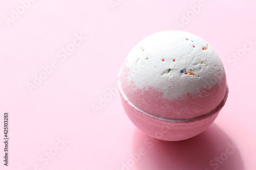 DIY Birthday Cake Bubble Bath Bomb with sprinkles on pink background. Pink salt bomb on colored pastel backdrop. Top view, copy space. Natural beauty spa body care product 