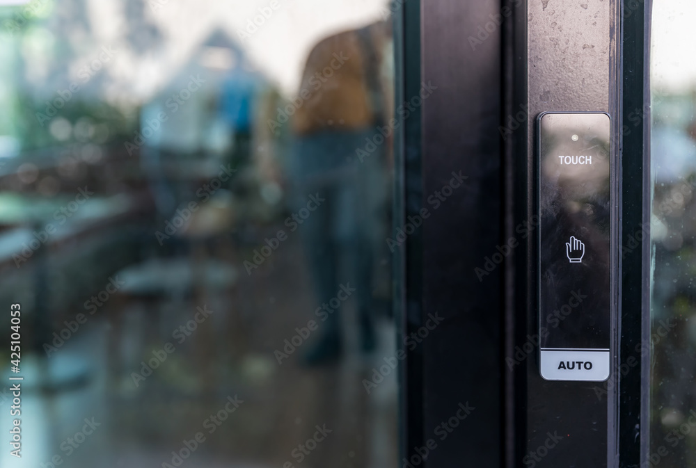 Automatic sliding door with wireless push button for user controller. wireless  push button or press button activation switch for automatic door opening on  white wall in building. Closed up view. Stock Photo