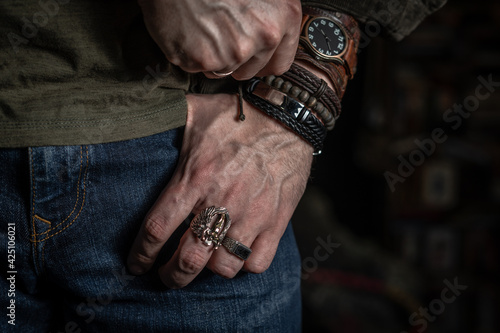 Stylish man wears wrist wooden and leather bracelets